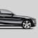 Side view of a gleaming black sedan with shiny chrome wheels